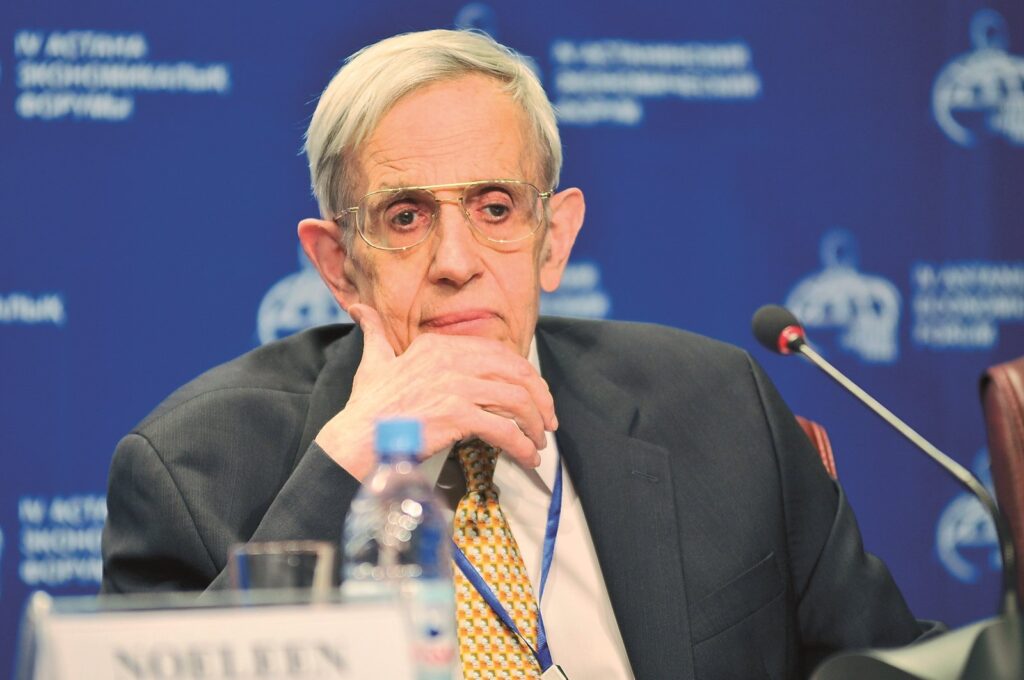 John Forbes Nash Jr. duduk bertopang dagu di meja panel sebuah forum ekonomi pada 2011