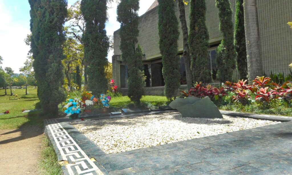 Makam keluarga Escobar berlapis kerikil putih dengan bunga di Pemakaman Jardines Montesacro, Itagüí