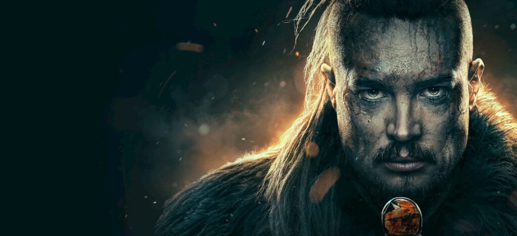 Materi promosi resmi The Last Kingdom: Seven Kings Must Die menampilkan wajah Alexander Dreymon sebagai Uhtred berlatar gelap