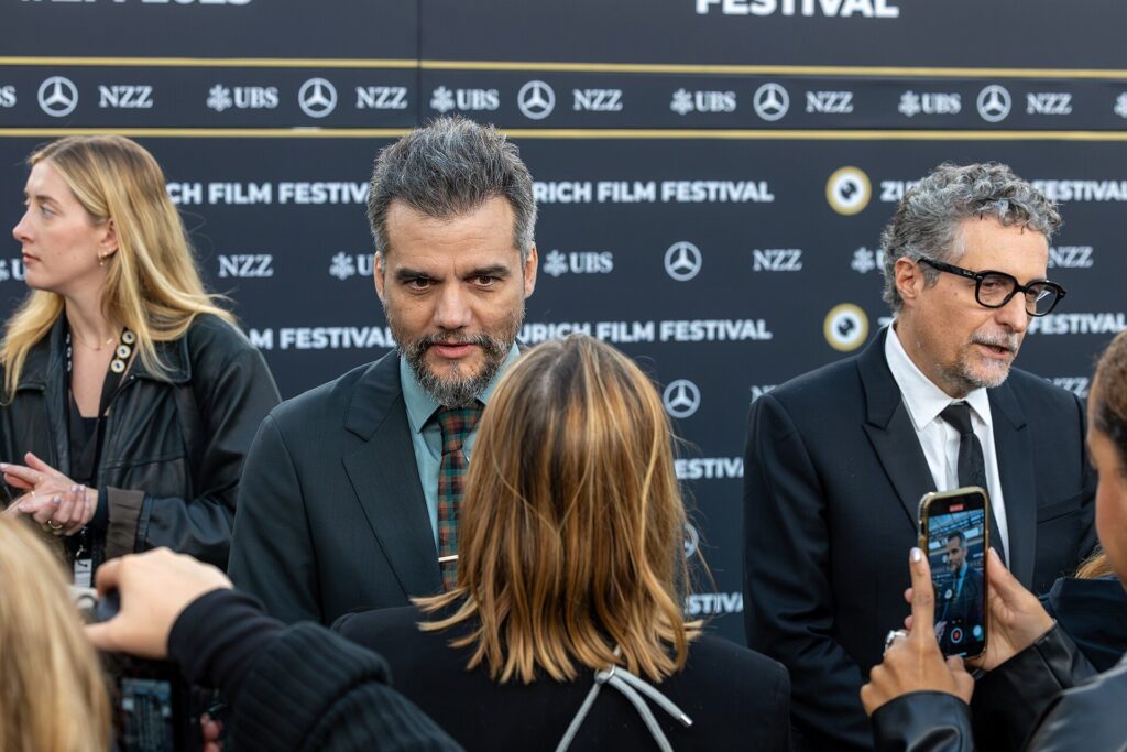 Aktor Wagner Moura berjas gelap diwawancarai di karpet hijau Zurich Film Festival 2025